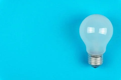 Light bulb on a blue background on the right. Top view Stock Photos