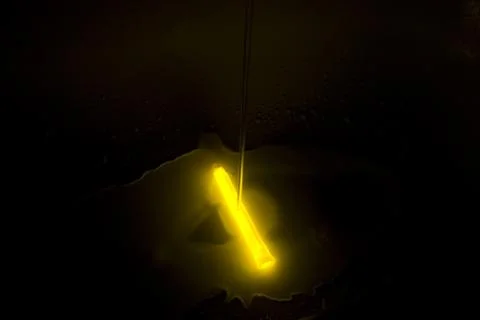 Light bulb on the ceiling, yellow light bulb on a black background Stock Photos