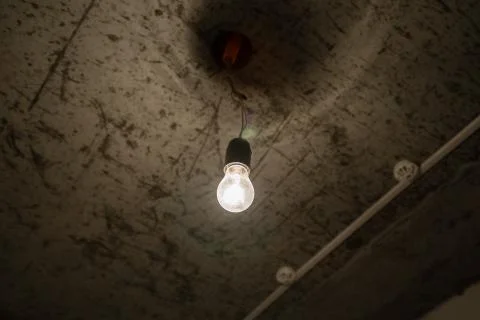 Light bulb close-up in a dark room. Stock Photos
