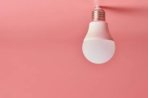 Light bulb, copy space. Energy saving minimal idea concept.Pink background. Stock Photos