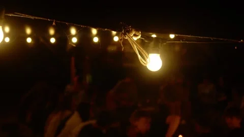 A light bulb, covered in cobwebs, is lit on the street, with midges buzzing Stock Footage 280701396