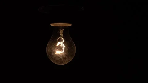A light bulb in a dark basement blinks due to voltage drop. An old glass light Video stock 291583862