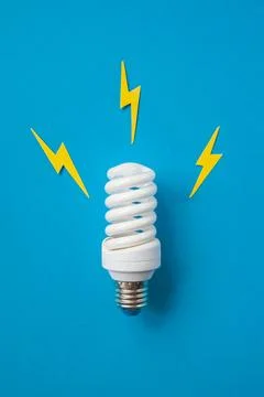 Light bulb with energy lightings on blue background Stock Photos