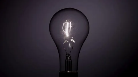 Light bulb filament flickers on then stays bright briefly Stock Footage 329657287