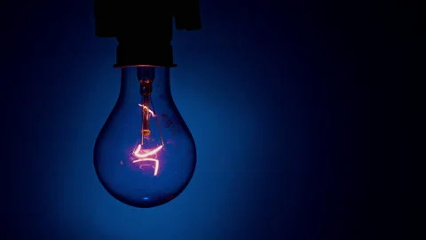Light Bulb Flashes on a Blue Background in the Dark Stock Footage 236930161