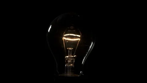 Light bulb flickering and turning on. 4k Black background Stock Footage 89648803