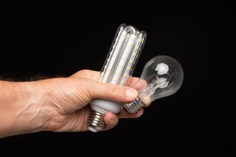 Light bulb in hand on a black background Stock Photos