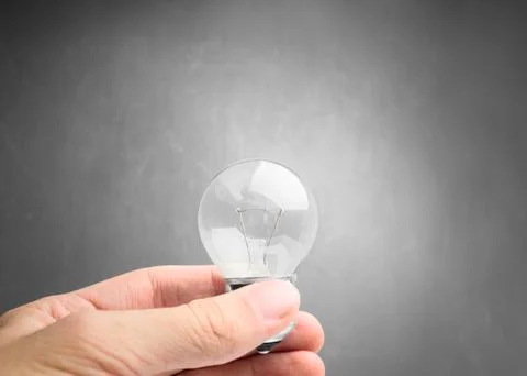 Light bulb in hand on gray background Stock Photos