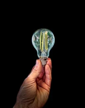 Light bulb in hand, idea and inspiration concept on dark background 스톡 사진
