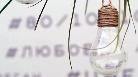 A Light Bulb is Hanging on a Rope a White Background With Blured Russian Words. Stock Footage 68851124