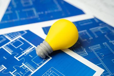 A light bulb idea on blue drawings. Idea and engineering thought. Energy infr Stock Photos