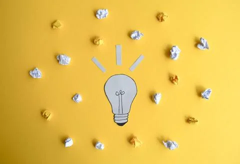 Light Bulb Idea with Crumpled Papers on Yellow Foto stock