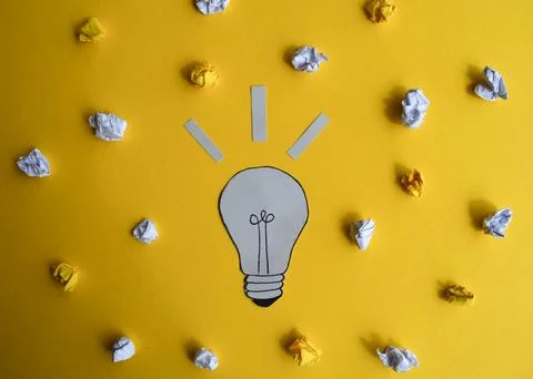 Light Bulb Idea with Crumpled Papers on Yellow Stock Photos