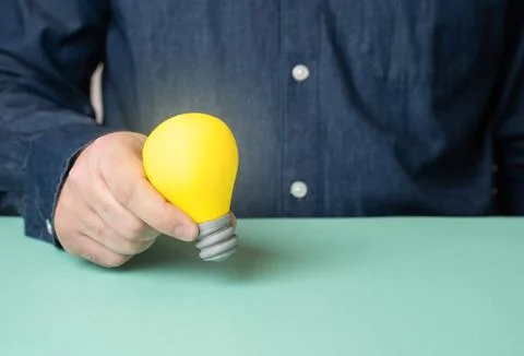 A light bulb is an idea in a man's hands. To come up with an idea, to come to Stock Photos