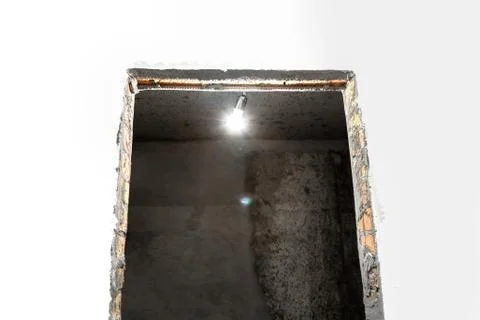 Light bulb illuminates a dark room. Stock Photos