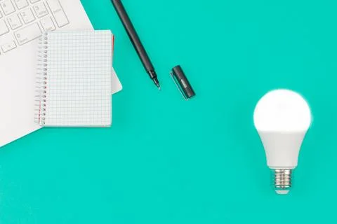 Light Bulb, Laptop and Notepad on Blue Background. Idea Concept Stock Photos