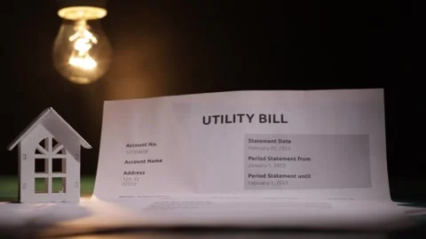 The light bulb lights up with the utility bill and the house, tax invoice, .. Stock Footage 309987519