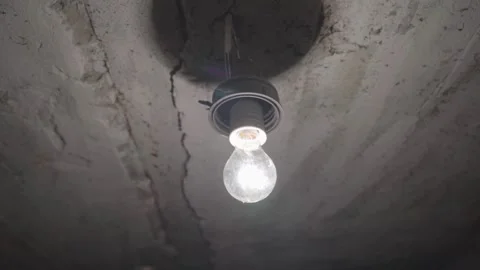 A light bulb is lit up in a dark room Stock Footage 289472559
