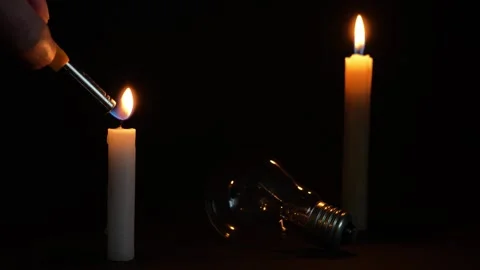 The light bulb is lying on the table. Two candles light near it Stock-Footage 320194484