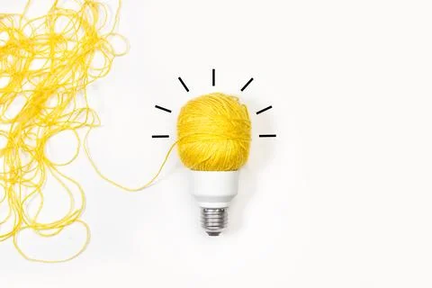 Light bulb made with a yellow thread on a white background 스톡 사진