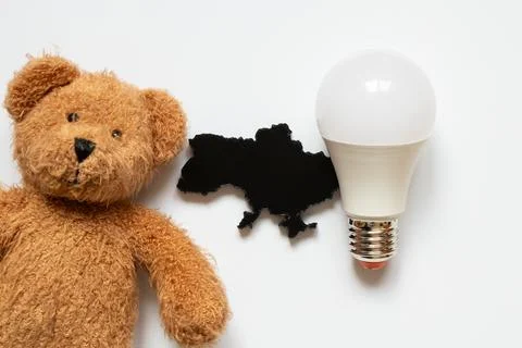 A light bulb next to a black 3D outline of the map of Ukraine and a child's.. Stock Photos
