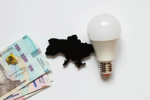 A light bulb next to a black, three-dimensional outline of a map of Ukraine.. Stock Photos