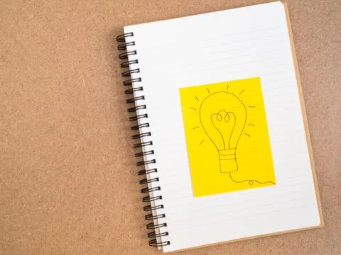 Light bulb on note paper concept of idea Stock Photos