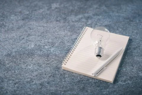 Light bulb on notebook shows knowledge, idea, learning, concept, creative i.. Stock Photos