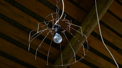 Light bulb in an old lampshade Stock Footage 117478125