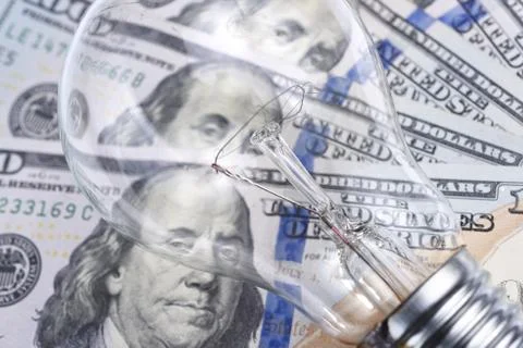 Light bulb over dollar bills Stockfoto's