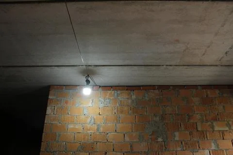 A light bulb in the room. Dim lighting and crime. Preservation of light and h Stock Photos