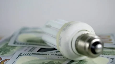 Light bulb rotate on 100 usd note bills Increase in electricity tariffs Stock Footage 273872963