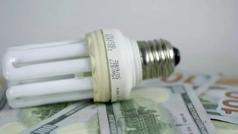 Light bulb rotate on 100 usd note bills Increase in electricity tariffs Stock Footage 273873028