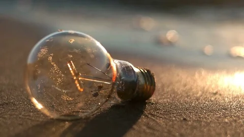 Light bulb on the sand beach Stock Footage 76850237