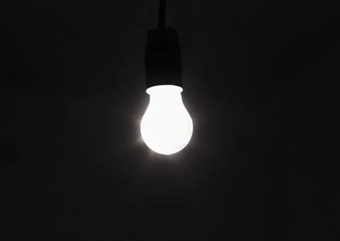 Light bulb shines a bright light, soft focus Stock Photos