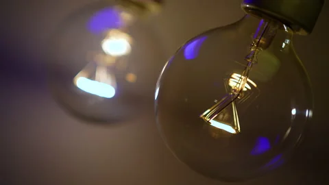 The light bulb slowly lights up in the dark and goes out. Stock Footage 223920414