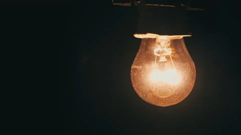 Light Bulb Slowly Turned On and Off on Black Background Stock Footage 179960731