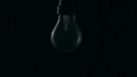 Light bulb swinging to camera and turning on. Slow motion. Stock Footage 72607175