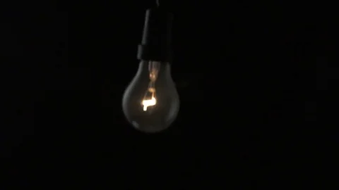 Light bulb swinging to camera and turning on. Slow motion. Stock Footage 72607500