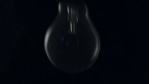 Light bulb swinging to camera and turning on. Slow motion. Stock Footage 72607629