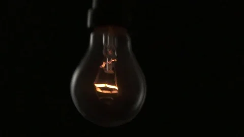 Light bulb swinging to camera and turning on. Slow motion. Stock Footage 72607637