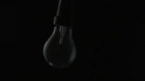 Light bulb swinging to camera and turning on. Slow motion. Stock Footage 72607652