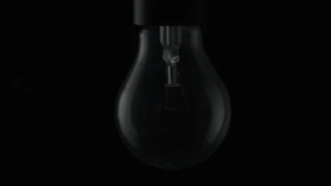 Light bulb swinging slightly and turning on. Slow motion Stock Footage 72607620