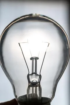 Light bulb turned off, oriented towards the sun. Electricity and renewable sourc Stock Photos