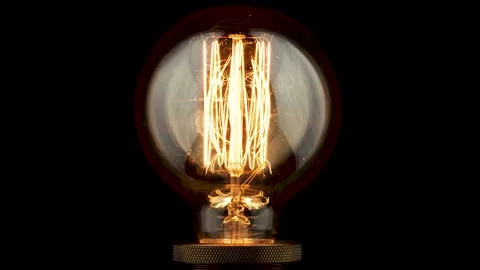 Light bulb turning on and off on black background Stock Footage 233147051