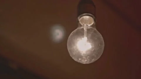 Light Bulb Turning On and Off Blinking Over Dark Background Video stock 331774358