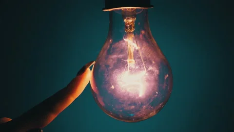 Light Bulb Turns On and Goes Out at the Touch of a Person's Hand in the Dark Stock Footage 237364247