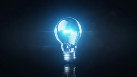 Light Bulb Turns On in the Dark. Bright Shining Lightbulb Like Idea Symbol Stock Footage 310742557