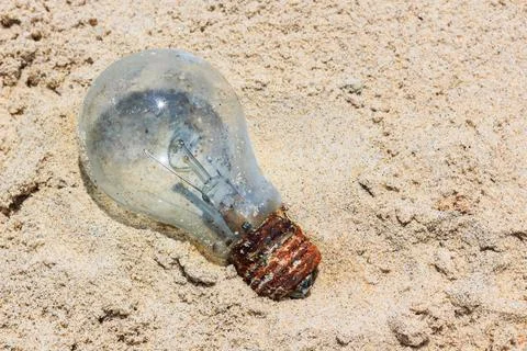 Light bulb was throw away on the beach. Outdoors. Stock Photos