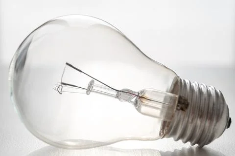 Light bulb on white surface. Stock Photos